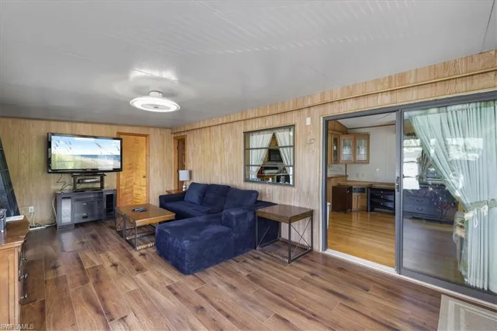 Living room featuring wooden walls and wood finished floors
