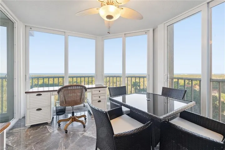 Sunroom featuring healthy amount of natural light, marble tiled floors, and a wall of windows