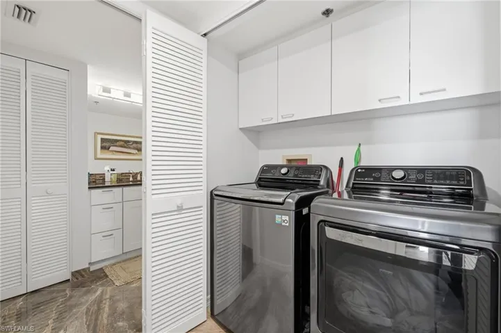 Laundry room with cabinet space and washing machine and clothes dryer