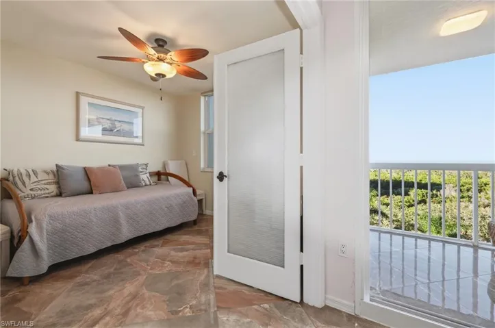 Bedroom featuring stone finish floors and ceiling fan
