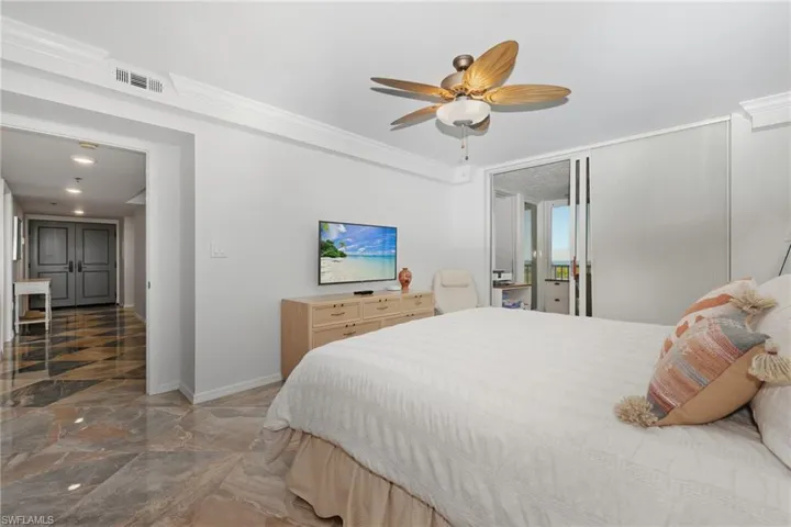 Bedroom with access to exterior, marble tiled flooring, a ceiling fan, and crown molding
