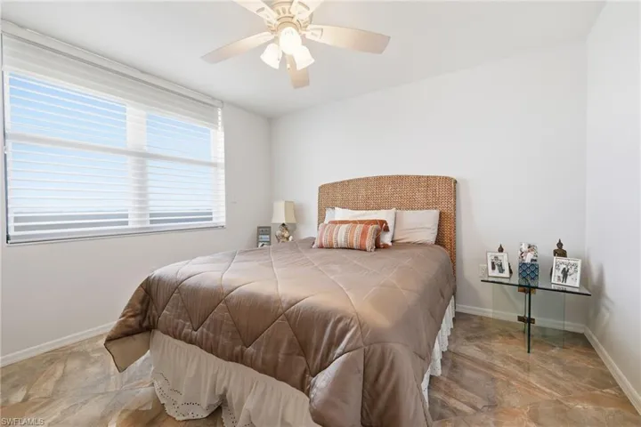 Bedroom with a ceiling fan and stone finish floors
