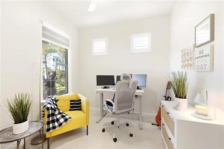 Bright room featuring a large window with exterior landscaping, white walls, recessed lighting, and tile flooring