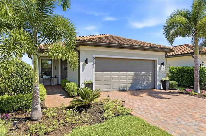 Mediterranean-style facade featuring a terracotta tile roof and textured stucco exterior