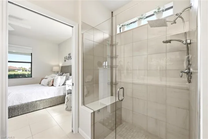 Glass-enclosed shower featuring a built-in bench, dual shower heads, and tile-finish walls