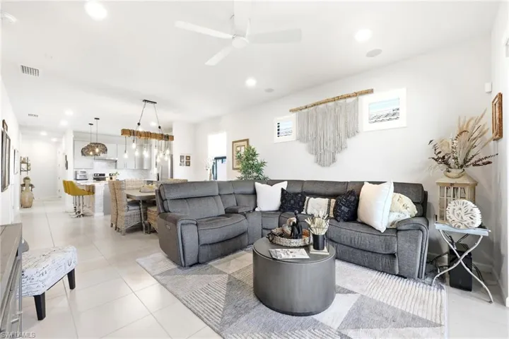 Open-concept living area featuring light-toned tile flooring and recessed lighting