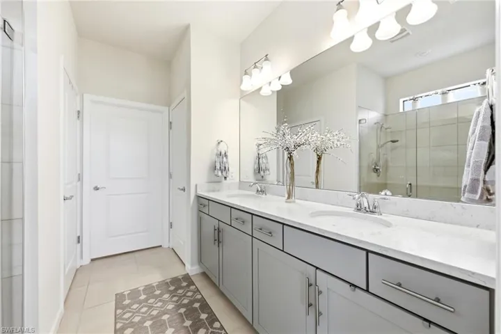 Dual vanity with light gray cabinetry and white countertops
