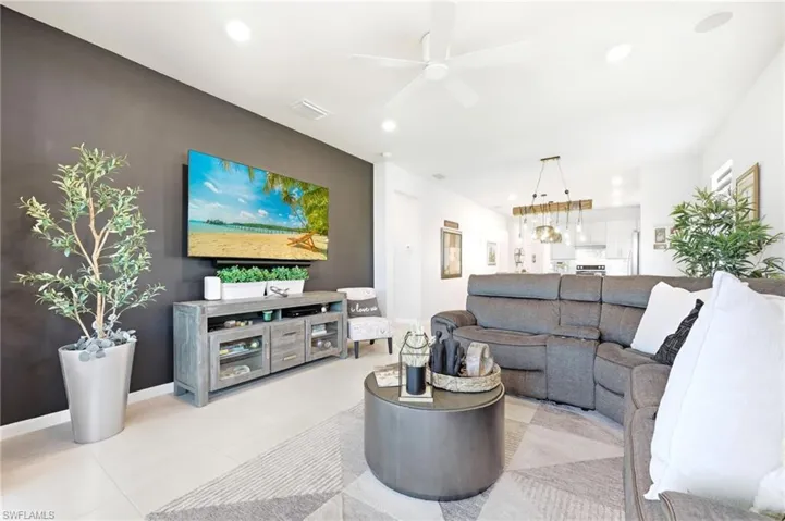 Living area featuring light-toned flooring, a contrasting accent wall perfect for movies!