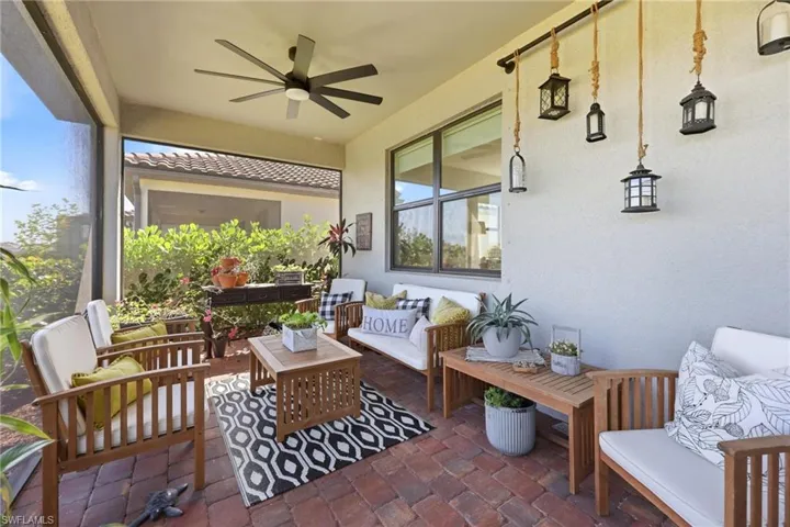 Screened patio featuring brick pavers and a ceiling fan