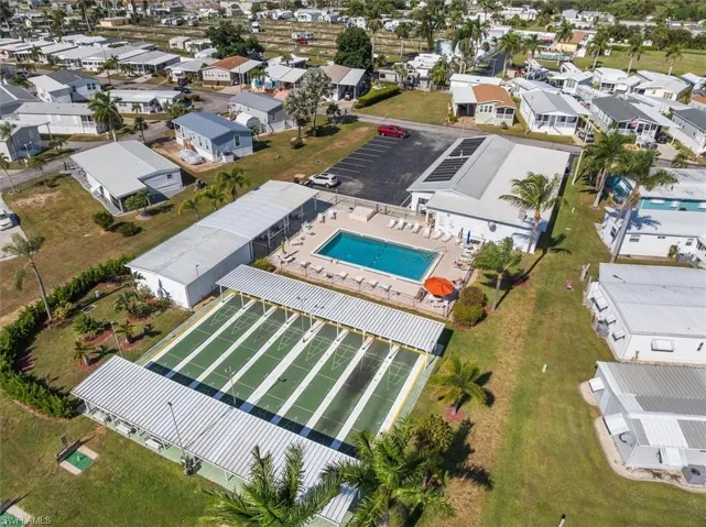 Aerial overview of property's location with a pool and nearby suburban area