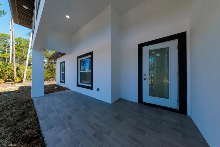 Property entrance with stucco siding and a patio area