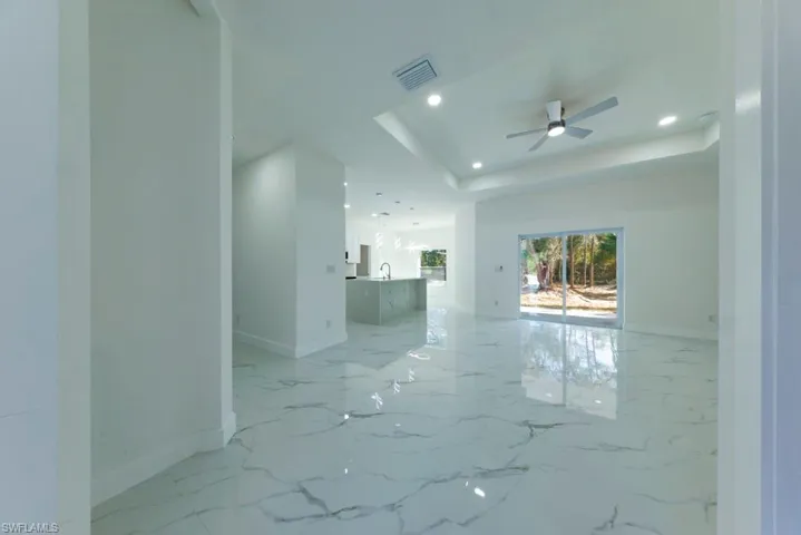 Spare room with a ceiling fan, a raised ceiling, and recessed lighting