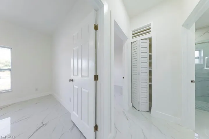 Hall with light marble finish floors and baseboards