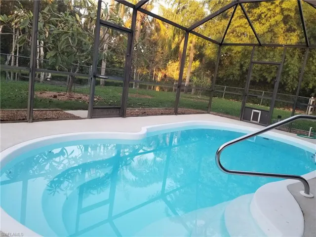 View of swimming pool with a lanai