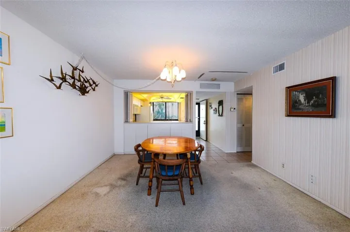 VIEW FROM LIVING AREA TOWARDS DINING, KITCHEN AND UNIT ENTRANCE.  GUEST BEDROOM ENTRANCE SHOWN AT MIDDLE RIGHT.