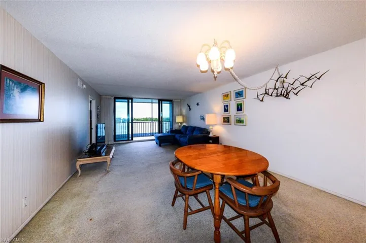 VIEW FROM DINING AREA TOWARD LIVING AREA AND LANAI.  IMPACT RESISTANT LANAI DOORS.