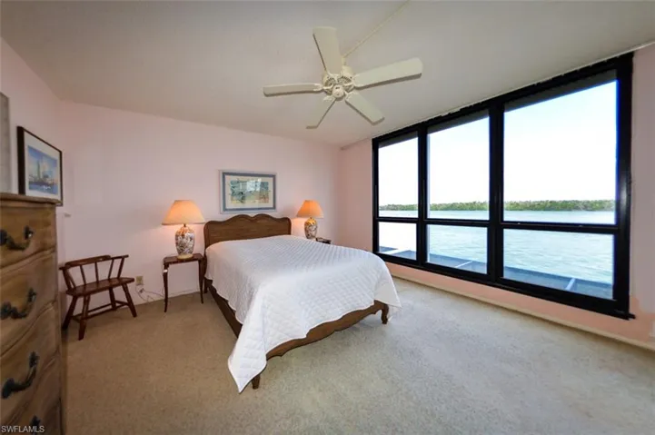 OWNER'S SUITE WITH FULL ESTERO BAY VIEWS FROM THE IMPACT RESISTANT NEARLY FLOOR-TO-CEILING WINDOWS.  ENTRANCE TO LANAI IS TO RIGHT.  ENTRANCE TO EN-SUITE BATH IS TO LEFT.