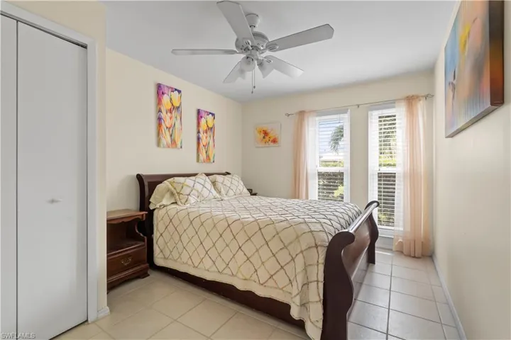 Tiled bedroom with a closet and ceiling fan