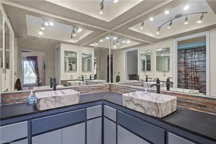 Bathroom featuring track lighting and double vanity