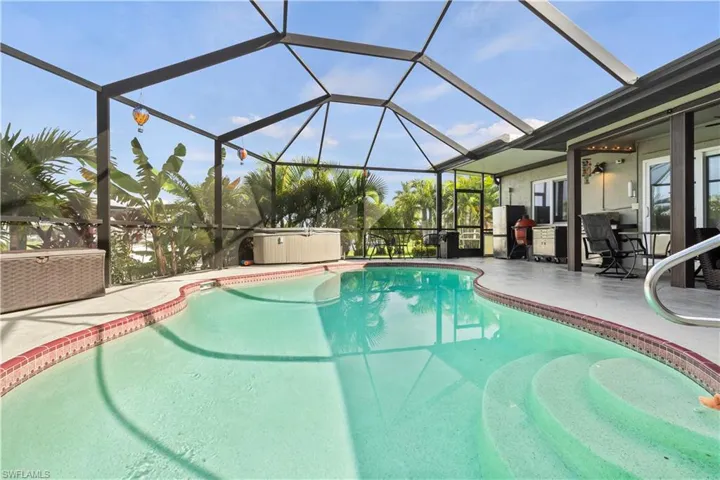 View of swimming pool featuring glass enclosure and a patio area