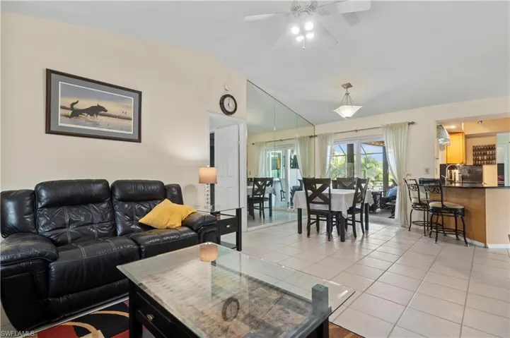 Tiled living room featuring lofted ceiling and ceiling fan