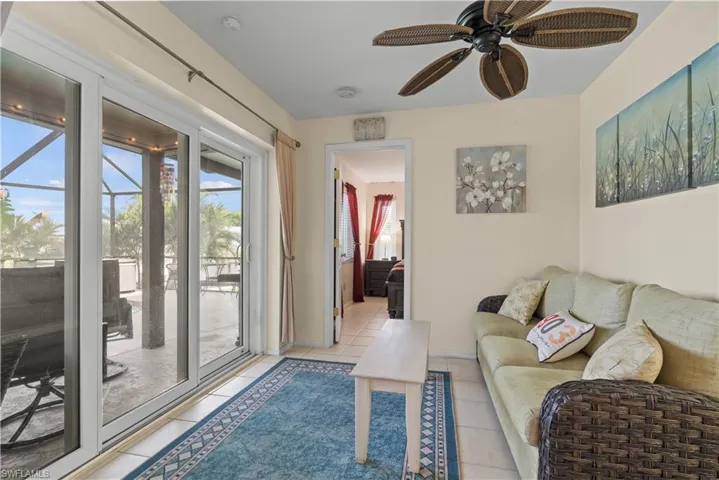 Tiled living room featuring a wealth of natural light and ceiling fan