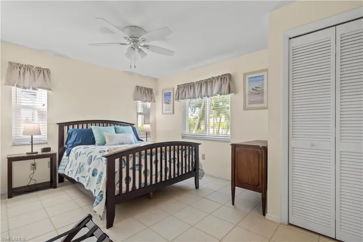 Bedroom with ceiling fan, a closet, and light tile floors