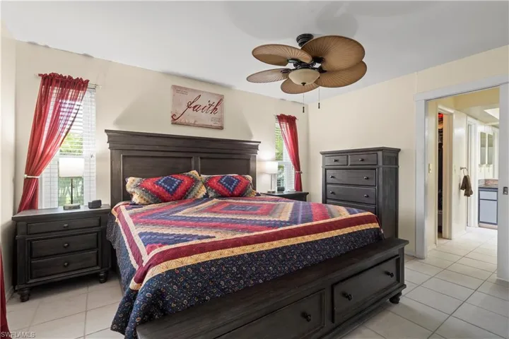 Bedroom with ceiling fan and light tile flooring