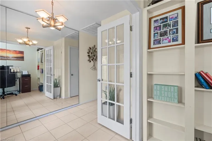 Doorway featuring a notable chandelier, french doors, and light tile flooring