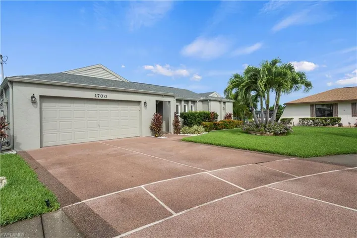 Single story home with a garage and a front yard