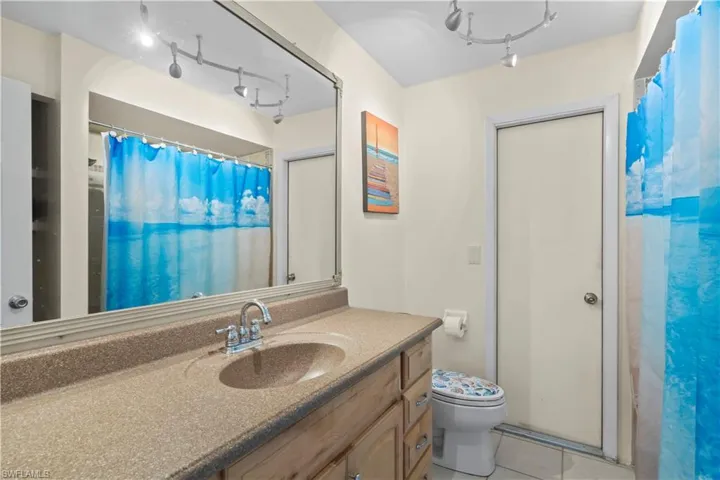 Bathroom featuring tile floors, large vanity, and toilet