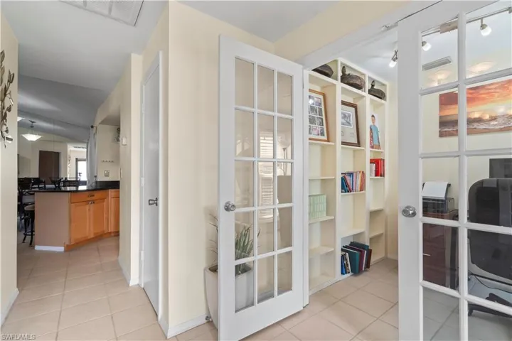 Home office featuring french doors, light tile floors, and rail lighting