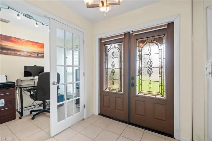 Entrance foyer with french doors, light tile floors, and rail lighting