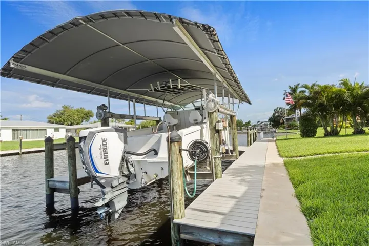 Dock area with a water view and a lawn