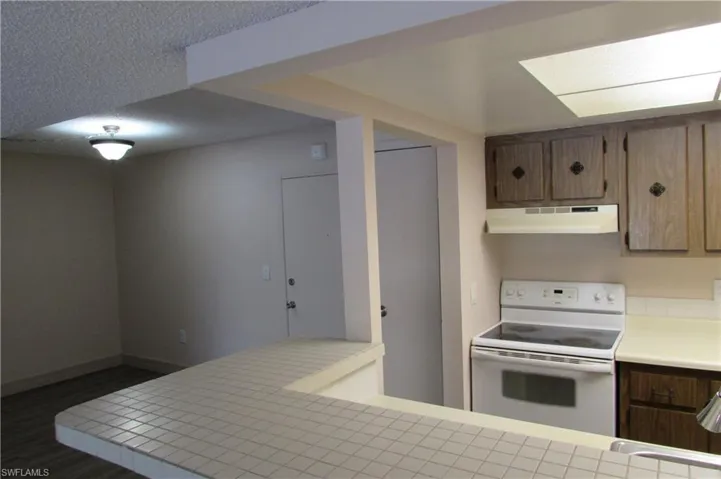 Kitchen with white range with electric cooktop and dark hardwood / wood-style floors