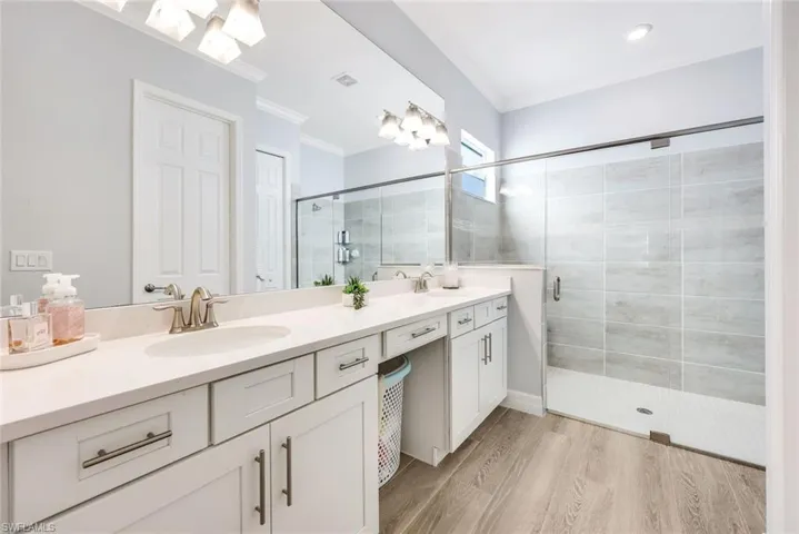 Modern primary bath with sleek finishes and a large, glass-enclosed shower.