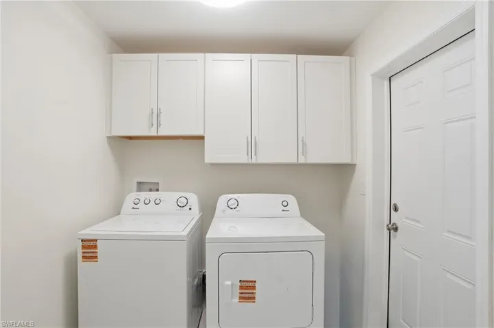 Laundry room featuring cabinet space and separate washer and dryer - Virtually Edited Image