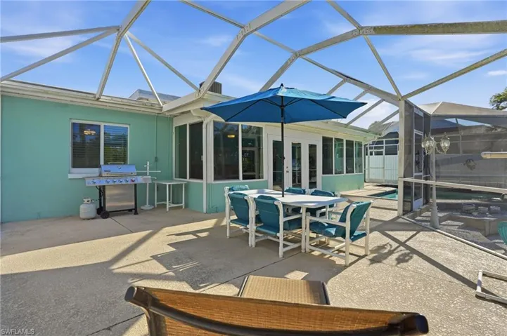 View of patio / terrace featuring a lanai, french doors, a sunroom, and outdoor dining area - Virtually Edited Image
