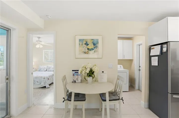 Dining space featuring washer / clothes dryer, light tile patterned flooring, and a ceiling fan - Virtually Edited Image