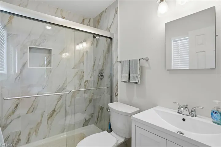 Full bath featuring vanity and a marble finish shower - Virtually Edited Image