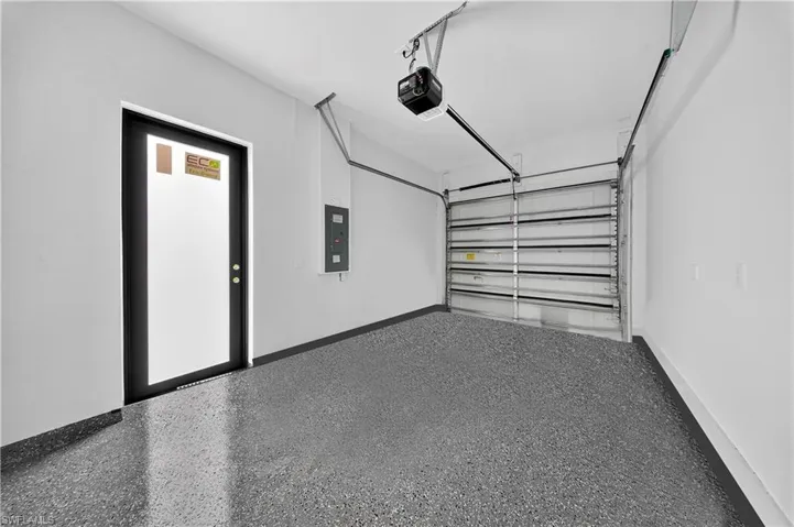 Garage featuring a garage door opener and electric panel