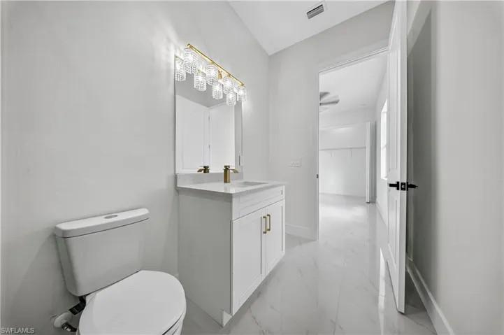 Bathroom featuring vanity and light marble finish floors