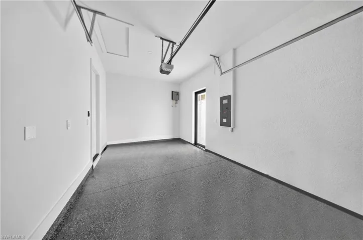 Garage with electric panel and baseboards