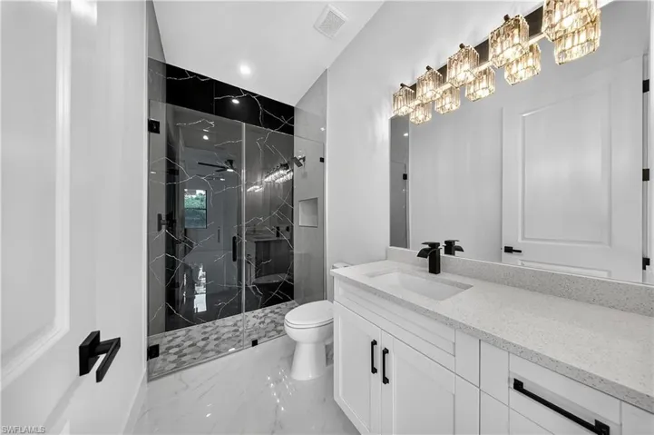 Full bathroom featuring light marble finish flooring, a marble finish shower, vanity, and recessed lighting