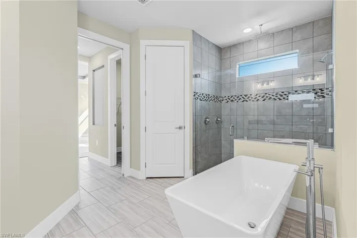 Bathroom with a freestanding tub, a shower stall, and recessed lighting