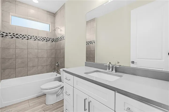 Full bath featuring vanity and washtub / shower combination