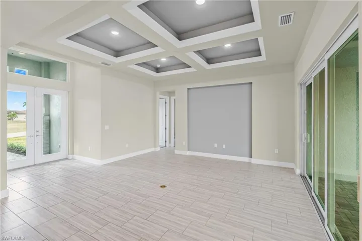Unfurnished room with french doors, coffered ceiling, recessed lighting, beam ceiling, and wood finish floors