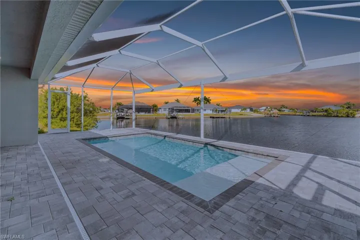 Swimming pool with a water view, a lanai, a sunroom, a patio area, and a boat dock