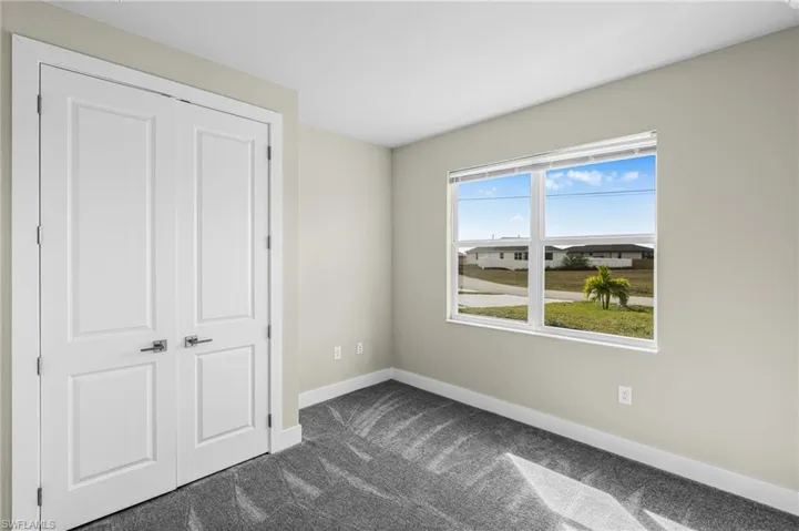 Unfurnished bedroom with a closet and dark carpet