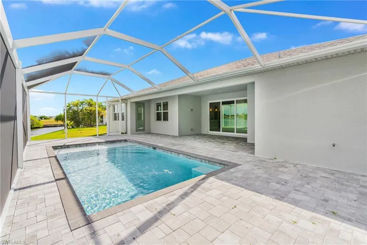 Outdoor pool featuring a sunroom, a patio area, and a lanai